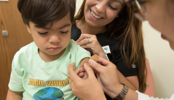A clinician administers a vaccine to a pediatric patient.