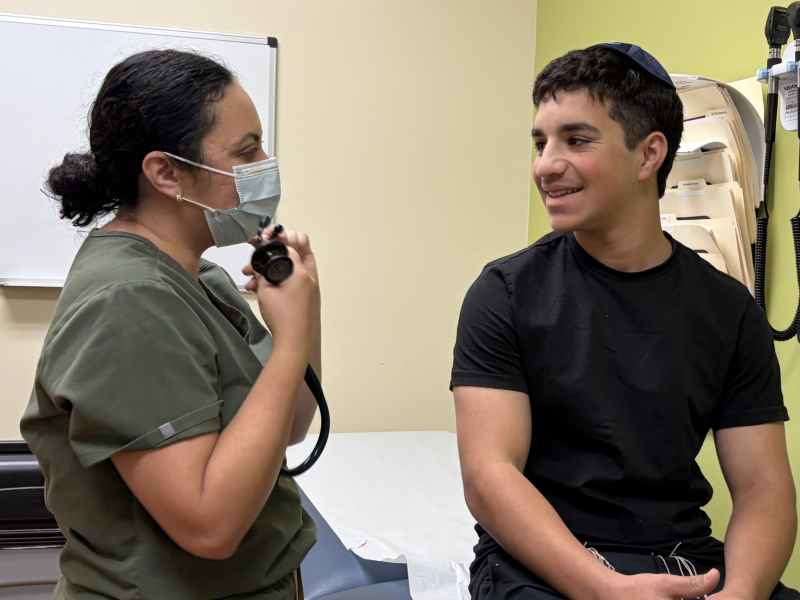 Dr. Romero meets with a pediatric patient during a clinic visit.
