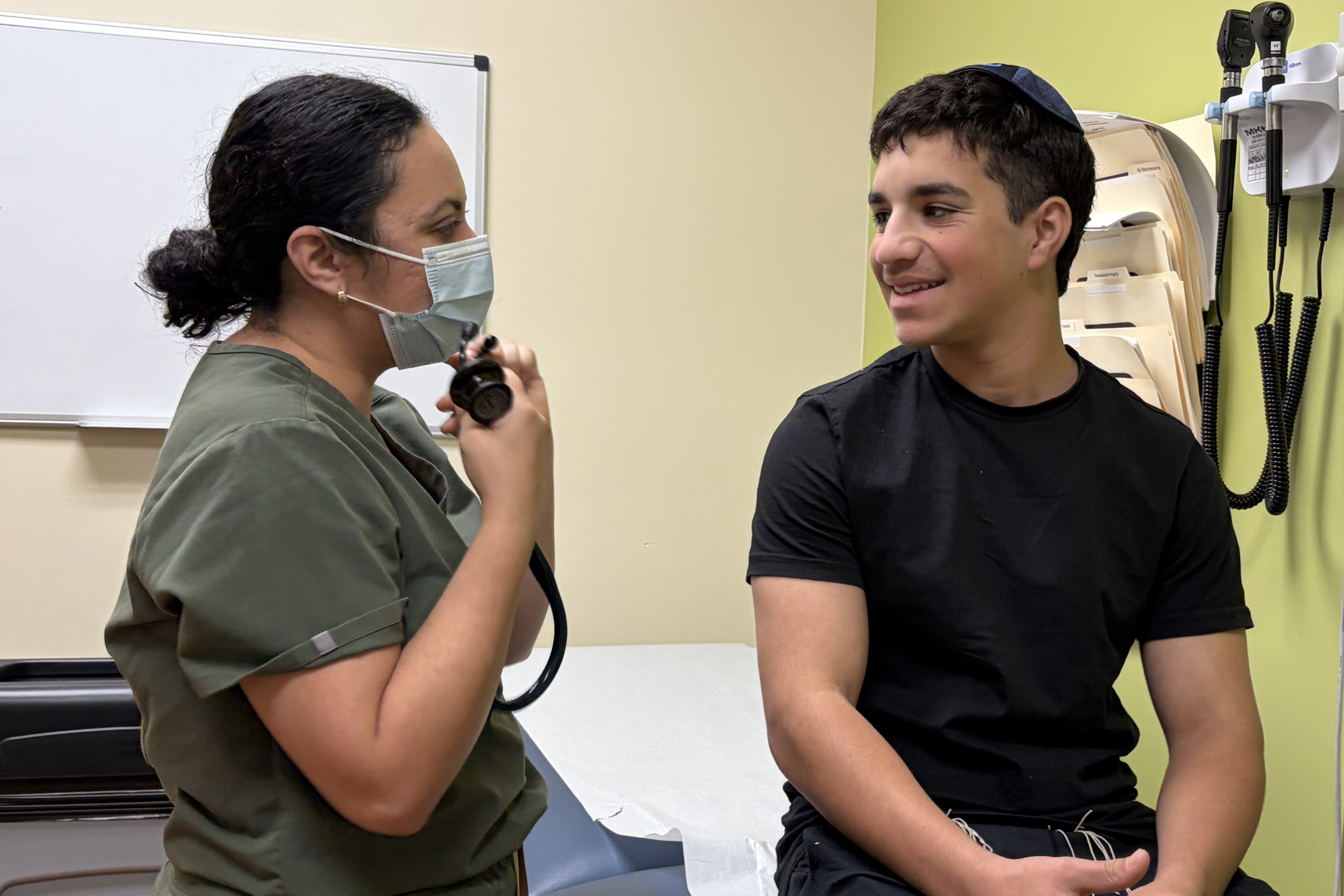 Dr. Romero meets with a pediatric patient during a clinic visit.