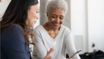 An elder patient meets with a clinician during a routine visit, receiving supportive care and guidance.