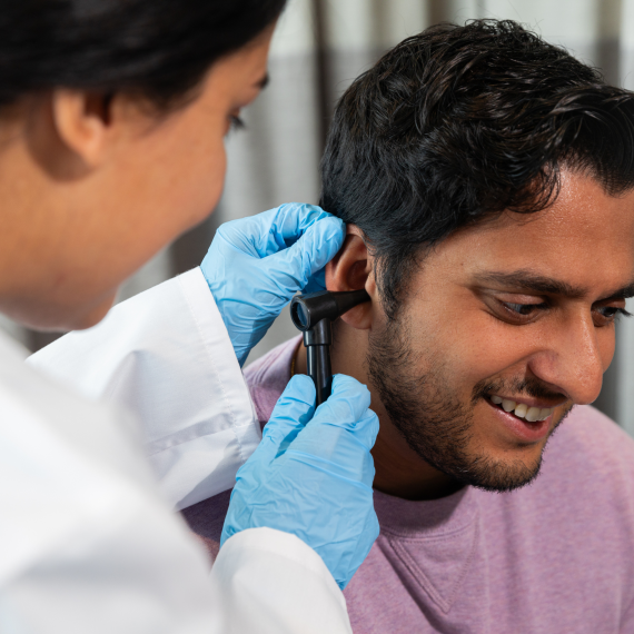 A doctor speaks with a patient during a consultation, reviewing health concerns and providing guidance.