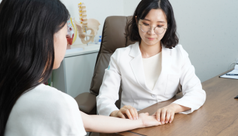 A clinician reviews bone health with a patient, discussing osteoporosis risk and preventive care during a routine visit.