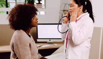 A female doctor meets with a patient against a light background, reviewing concerns and providing supportive, personalized care.