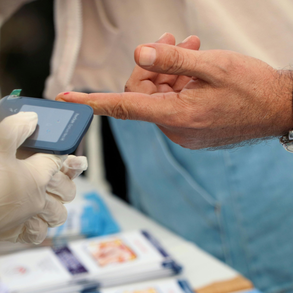 A clinician uses an A1c testing device to check a patient’s blood sample and verify results.